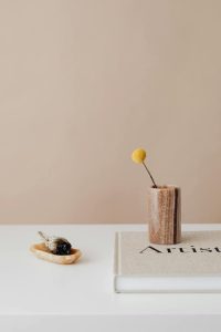Incense and a coffee table book on a white table